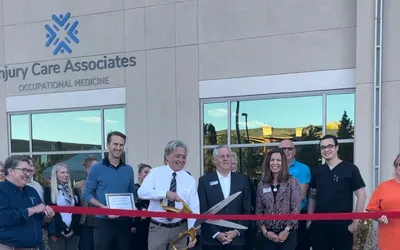 ICA staff and guests at a ribbon cutting outside an Injury Care Associates clinic