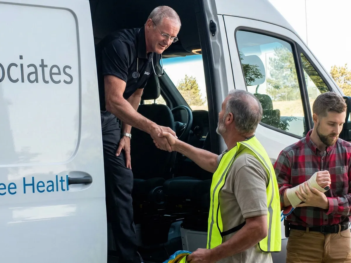 ICA nurse stepping out of the on-site van to greet a site supervisor while an injured worker waits