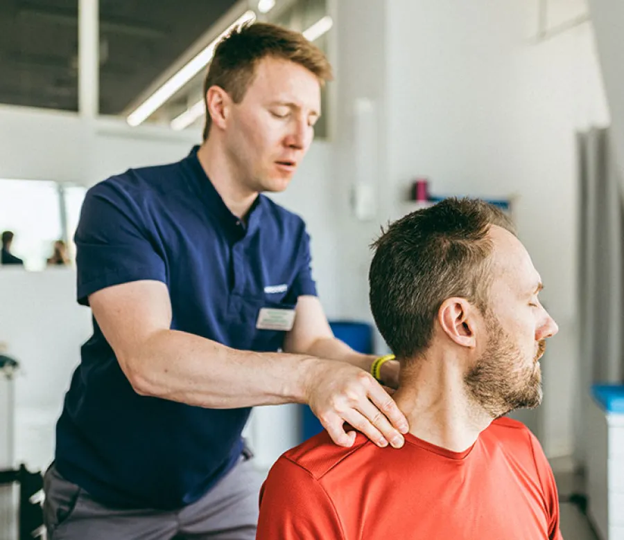 ICA therapist coaching warehouse employees on lifting technique at a worksite