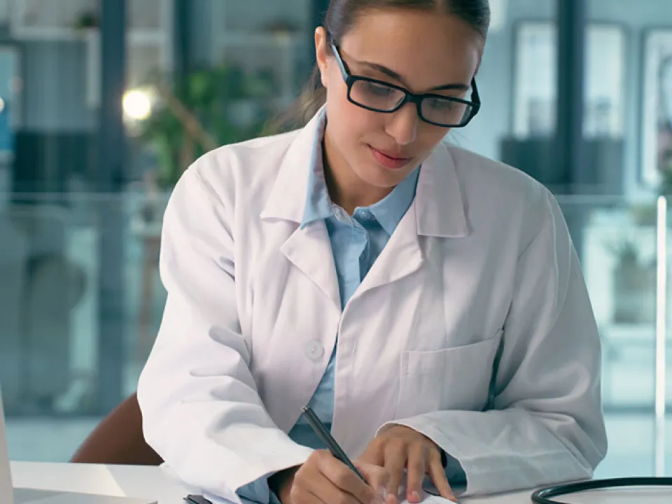 Occupational medicine clinician reviewing an employee’s surveillance file at an ICA clinic