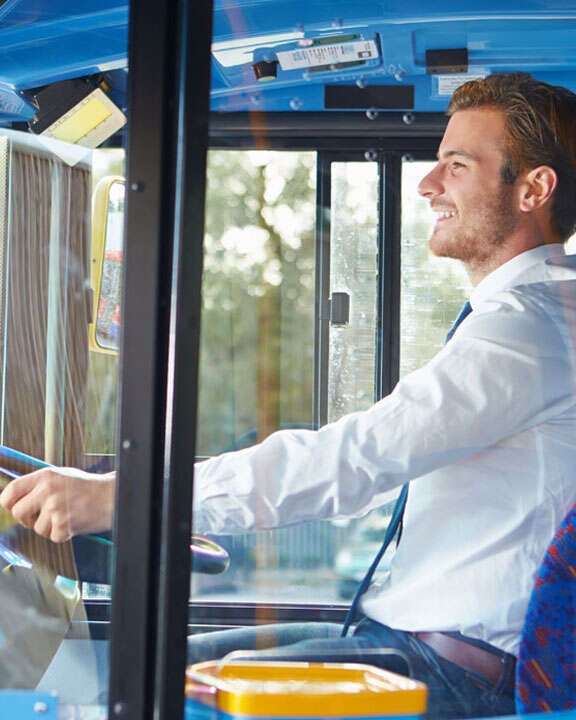 A person driving a passenger bus