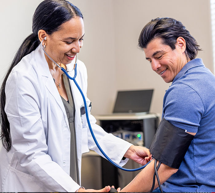 Clinician taking an employee’s blood pressure during a periodic physical at an ICA clinic